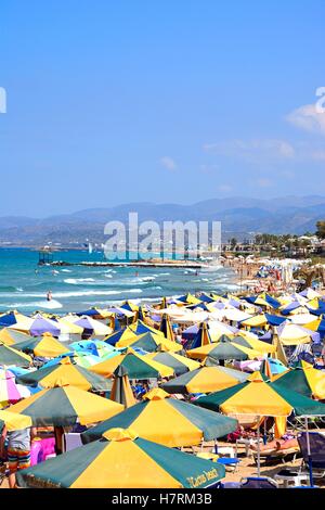 I turisti rilassante sulla spiaggia con vista lungo la costa, Stalida, Creta, l'Europa. Foto Stock