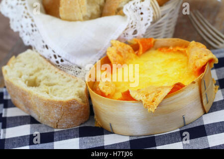 Formaggio cotto al forno e ciabatta pane su blu e bianco di panno a scacchi Foto Stock