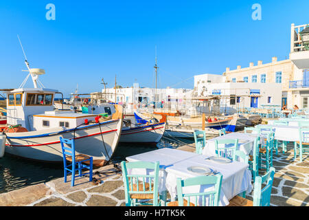 Tipica taverna greca tabelle nel porto di Naoussa, isola di Paros, Grecia Foto Stock