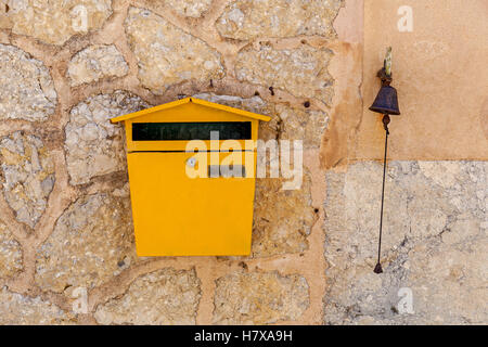 Postbox e una campana impostato in un muro di pietra,Postbox e una campana Foto Stock