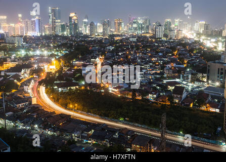 Una trafficata strada che conduce a Jakarta luminoso quartiere business di notte in Indonesia la città capitale. Foto Stock