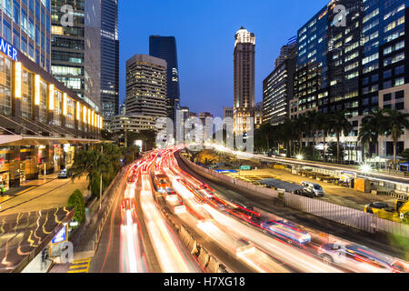 Il traffico pesante in Jakarta business district lungo i viali principali della città, Jalan Sudirman, durante la notte in Indonesia la città capitale Foto Stock