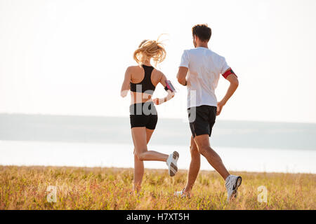 Vista posteriore del fitness giovane uomo e donna facendo jogging sport all aperto Foto Stock