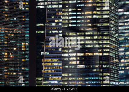Edifici per uffici in notturna a Singapore. Sfondo illuminato con i moderni grattacieli Foto Stock