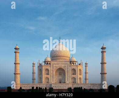 Una bella mattina bagliore arancione sulla parte anteriore facciata in marmo dell'iconico Taj Mahal centrata sotto un calmo mattino cielo blu da telep Foto Stock