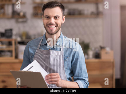 Felice giovane uomo sorridente in possesso di una cartella. Foto Stock