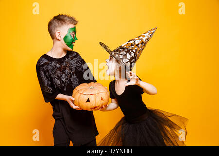 I bambini in costumi di Halloween a giocare con la zucca Foto Stock