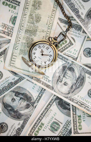 Orologio da tasca sulle banconote da cento dollari Foto Stock