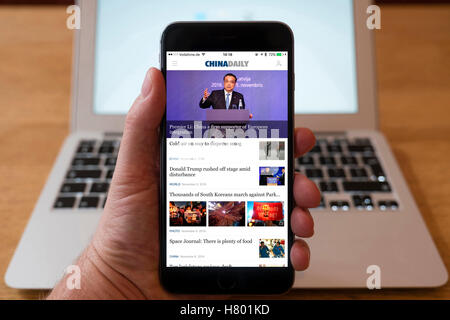 Utilizzo di iPhone smartphone per visualizzare in primo piano sulla homepage di China Daily giornali cinesi Foto Stock