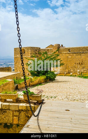 Il ponte levatoio in legno con la catena di nero sopra il fossato scavato nella Kasbah di EL KEF, Tunisia. Foto Stock