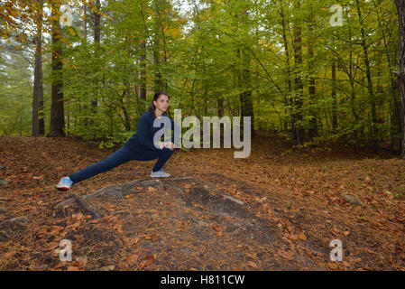 Energico giovane donna fare esercizi all'aperto nel parco per mantenere i loro corpi in forma. Concetto di fitness. Il body-building tema. Sport m Foto Stock