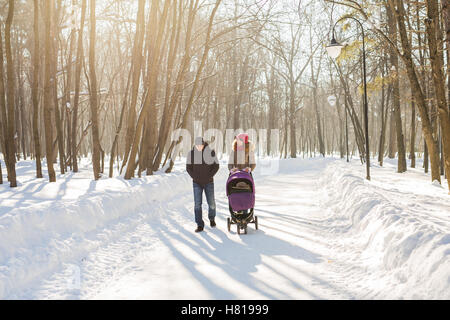 Famiglia giovane camminare con il passeggino in posizione di parcheggio Foto Stock