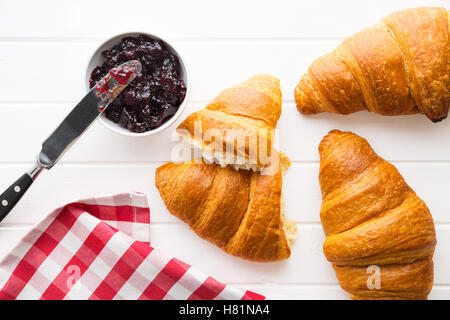 Gustosi croissant burroso e marmellata in barattolo. Vista dall'alto. Foto Stock