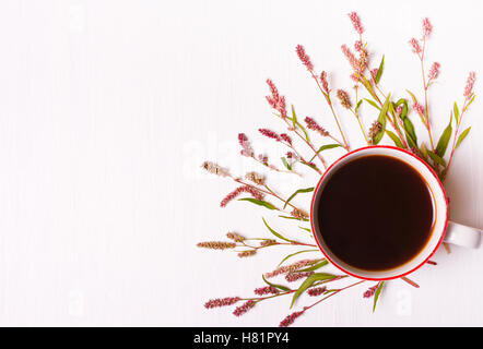 Tazza di caffè con fiori di colore rosa su sfondo bianco, vista dall'alto,buona mattina impostato Foto Stock