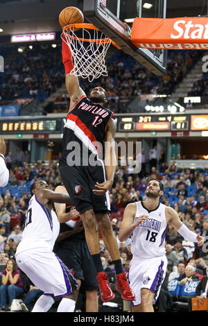 Gennaio 19, 2011; Sacramento, CA, Stati Uniti d'America; Portland Trail Blazers avanti potenza LaMarcus Aldridge (12) schiacciate passato i Sacramento Kings center Samuel Dalembert (10) e le piccole avanti Omri Casspi (18) durante il quarto trimestre di arco Arena. Portland sconfitto Foto Stock