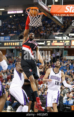 Gennaio 19, 2011; Sacramento, CA, Stati Uniti d'America; Portland Trail Blazers avanti potenza LaMarcus Aldridge (12) schiacciate passato i Sacramento Kings center Samuel Dalembert (10) e le piccole avanti Omri Casspi (18) durante il quarto trimestre di arco Arena. Portland sconfitto Foto Stock