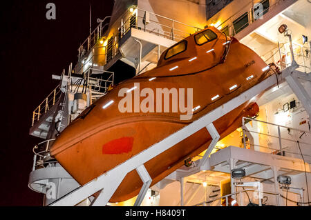 Vita arancione imbarcazioni su cruiseship ormeggiata al porto di attesa per i passeggeri a bordo Foto Stock