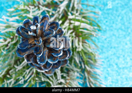 Pigne nelle quali e abete su sfondo spumanti. Decorazione di Natale sfondo Foto Stock