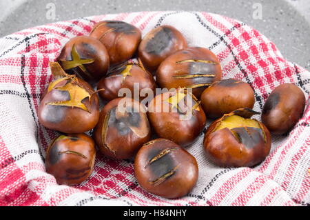 Castagne arrostite su una pietra brasiera Foto Stock