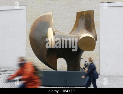 Muenster, Germania. 09Nov, 2016. La gente a piedi passato la scultura "l'Archer" (1966) di Henry Moore al di fuori della Vestfalia Museo Statale di Arte e storia culturale di Muenster, Germania, 09 novembre 2016. La mostra è la più completa fiera del lavoro di Henry Moore in Germania in 18 anni e può essere visto dal 11 novembre 2016 al 19 marzo 2017. Foto: ROLAND WEIHRAUCH/dpa/Alamy Live News Foto Stock