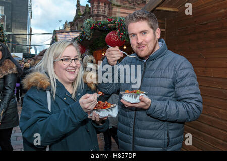 Glasgow, Scotland, Regno Unito. 10 Novembre, 2016. Di Glasgow e annuale di Natale popolare cibo internazionale e doni market si è aperto oggi a St Enoch Square nel centro della città con molte bancarelle mettendo a disposizione una vasta gamma di regali e cibi stranieri. PAUL McGUIRE, da RENFREW e ROBYN HENDRY da Glasgow sono godendosi un po' di stile Asiatico alimenti durante la loro pausa pranzo Credit: Findlay/Alamy Live News Foto Stock