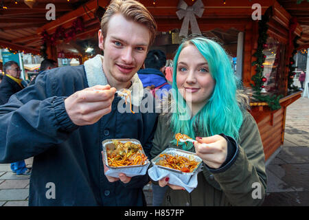 Glasgow, Scotland, Regno Unito. 10 Novembre, 2016. Di Glasgow e annuale di Natale popolare cibo internazionale e doni market si è aperto oggi a St Enoch Square nel centro della città con molte bancarelle mettendo a disposizione una vasta gamma di regali e cibi stranieri. CHLOE SISMEY da Kirkcaldy e DARREN HAMILTON da Glasgow sono godendosi un po' di cibo asiatico a pranzo. Credito: Findlay/Alamy Live News Foto Stock