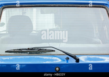 Chiusura del parabrezza posteriore braccio del tergicristallo e la spazzola su sun imbianchiti blu vintage autoveicolo Foto Stock