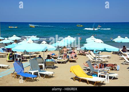 I turisti rilassante sulla spiaggia con vista verso il mare, Stalida, Creta, Grecia, l'Europa. Foto Stock