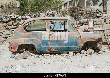 Vista di profilo di un arrugginito auto senza ruote Foto Stock