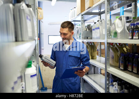 Auto meccanico con olio e appunti in auto shop Foto Stock