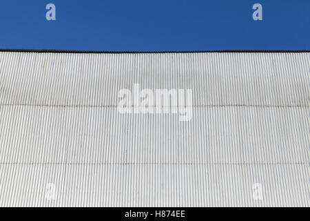 Edificio industriale parete in lamiera grecata, sotto il cielo blu Foto Stock