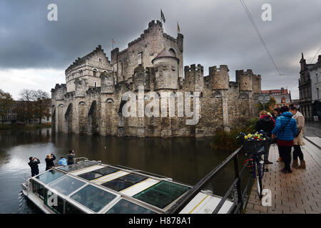 Belgio, Gand (Gent), il Castello dei Conti (Gravensteen) circondato dal fossato con i turisti su una barca di scattare le foto Foto Stock