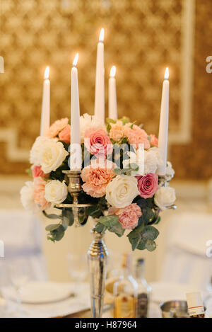 Bouquet di gara si erge sul candelabro in ristorante Foto Stock