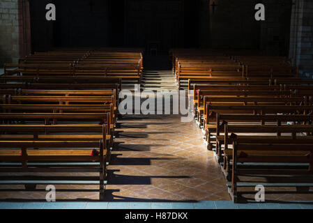 Fila di panche di legno all'interno di una chiesa in Spagna Foto Stock