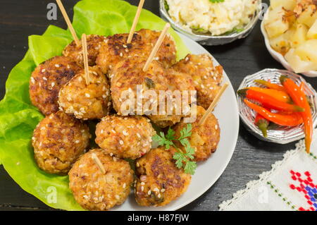 Le polpette di carne su bastoni in una piastra con verdure Foto Stock