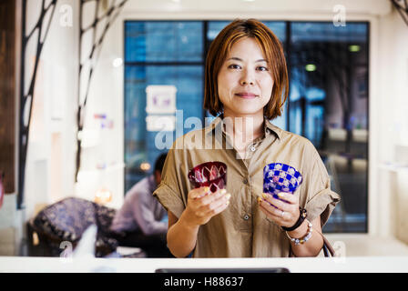 Commessa in un negozio di vendita di Edo Kiriko vetro tagliato a Tokyo in Giappone. Foto Stock