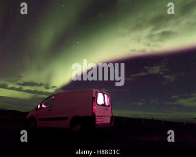 Vista mozzafiato di Dancing Aurora Boreale su un bianco Camper, Islanda Foto Stock