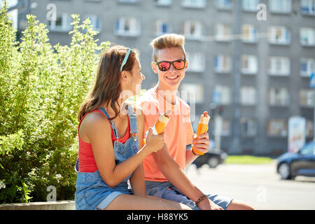 Felice coppia adolescenti mangiare hot dogs in città Foto Stock