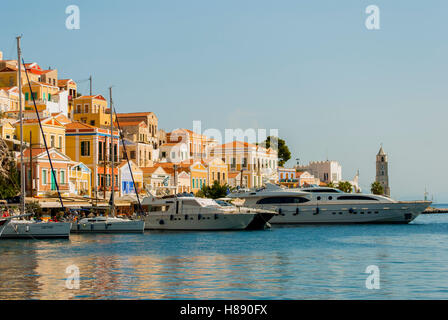 Yacht e Barche a motore ormeggiata nel porto di yialos su symi grecia Foto Stock