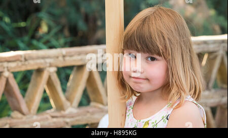 Carino Caucasian bambina in piedi sul balcone, close-up ritratto all'aperto Foto Stock