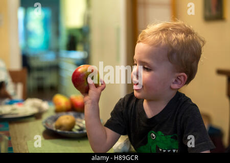 Detroit, Michigan - due-anno-vecchio Adamo Hjermstad Jr. si prepara a lanciare un apple attraverso il tavolo per la cena. Foto Stock