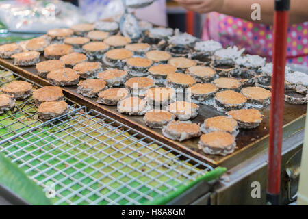 Babin candy è in stile Thai street cocco frittella dolce ,il vecchio Thai dessert in all'aperto sotto ombrellone illuminazione. Foto Stock