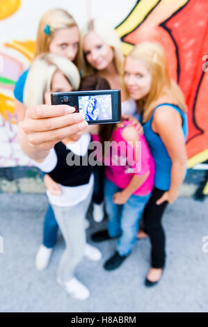 Un gruppo di ragazze adolescenti di fronte a un muro di graffiti Foto Stock