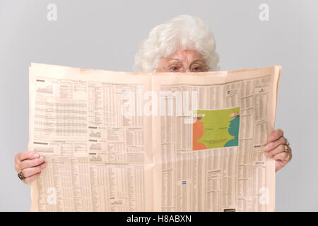 Senior donna leggendo un giornale Foto Stock