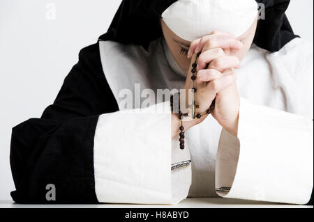 Nun pregando il Rosario Foto Stock