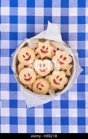 In casa Jammie Dodgers. La faccina sorridente i biscotti in una teglia Foto Stock