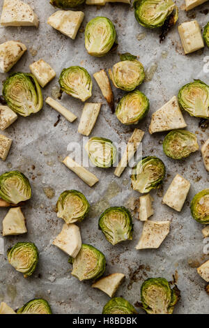 Verde al forno cavolini di Bruxelles sulla carta da forno con spezie Foto Stock