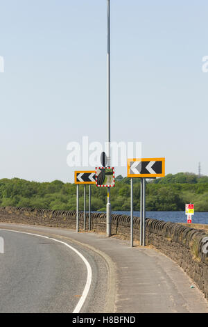 Sharp mano sinistra curva contrassegnata con la Chevron segni su una curva stretta sulla A673 come funziona passato Rivington inferiore serbatoio vicino Horwich, Lancashire. Foto Stock