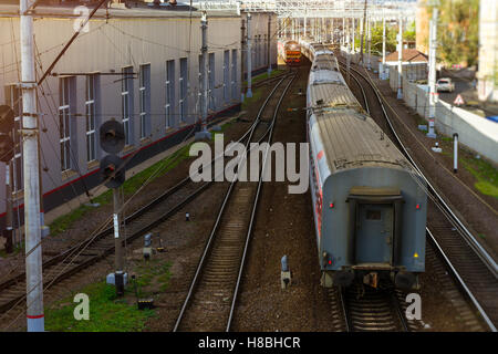 Ultimo vagone ferroviario. Locomotiva elettrica tirando con il treno ad alta velocità su rotaie. Tecnica stazione ferroviaria - la locomotiva di funzionamento deposito. Foto Stock