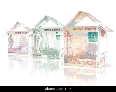 Le fatture del denaro ripiegato come case in piedi accanto a ogni altra in calo in dimensioni e valore. Foto Stock